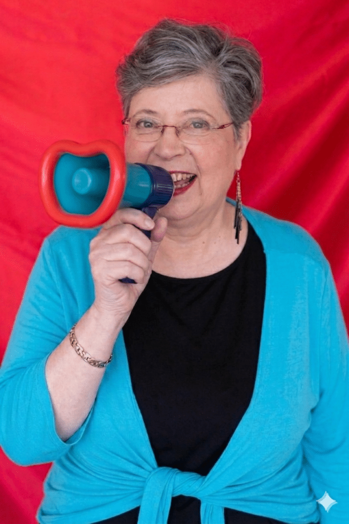 דורית לוז, מאמנת עסקית, מחזיקה מגפון, כדימוי של כלי למוטיבציה